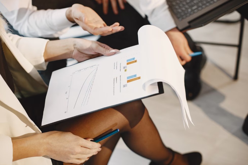 two office employees looking at a graph and creating a new project